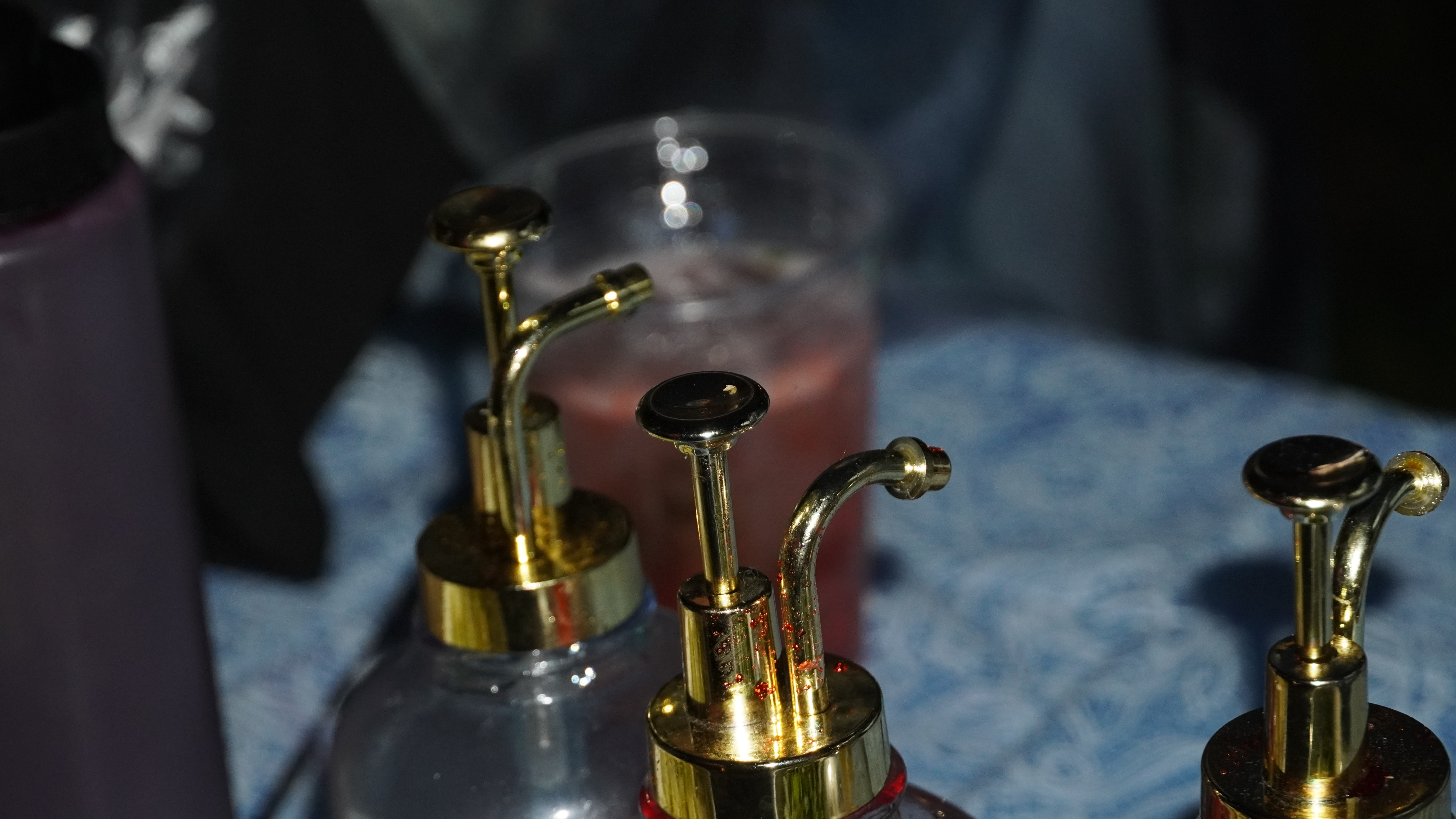 Golden syrup dispensers with colorful beverages